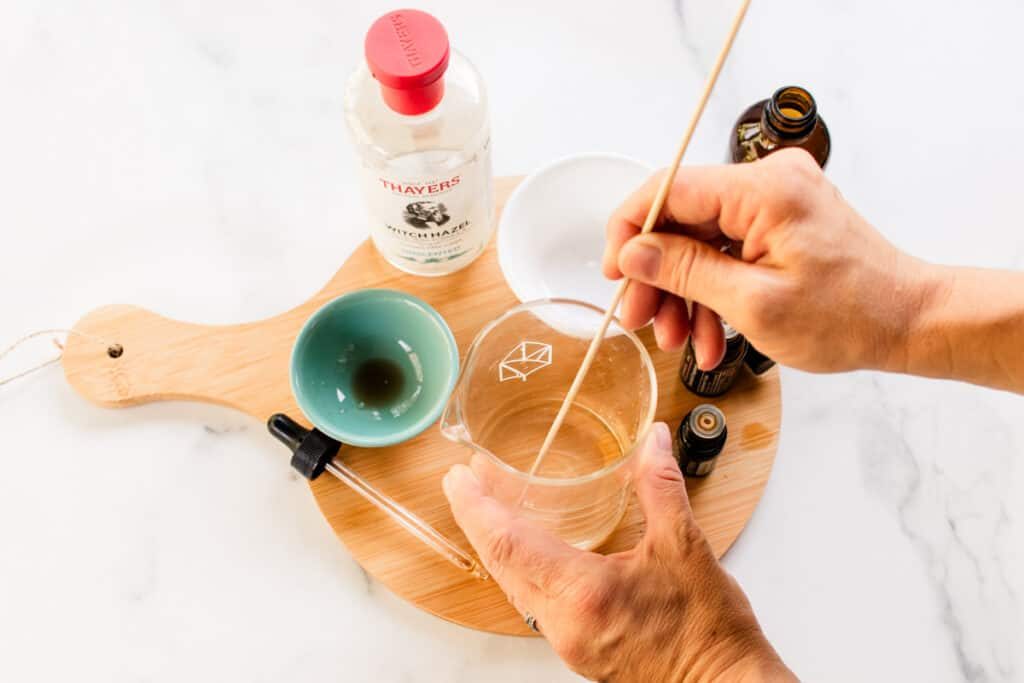 Stirring the hair perfume ingredients with a wooden stirrer.