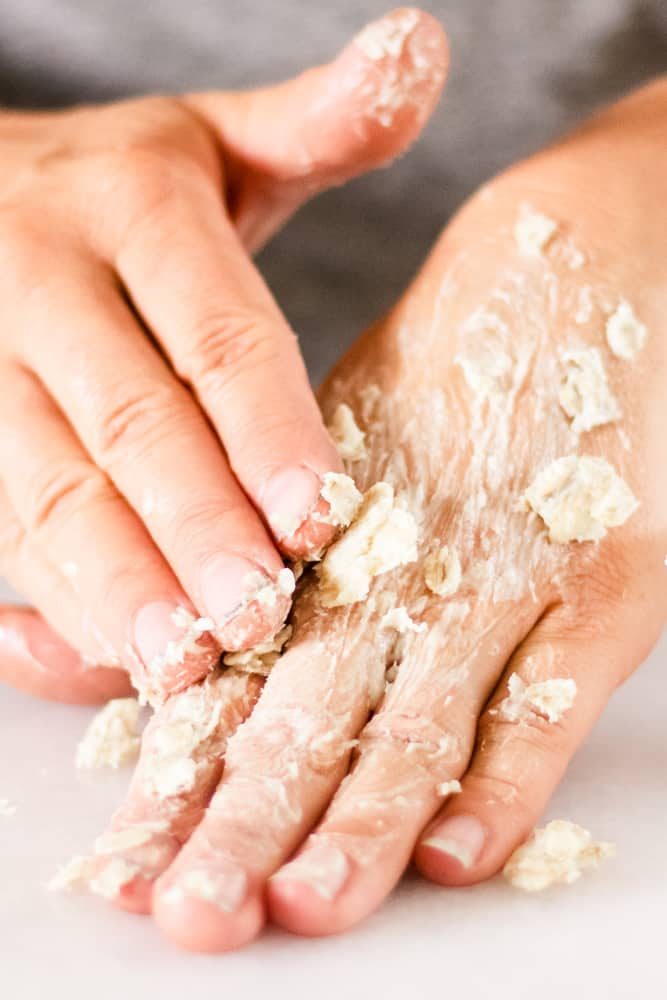 Massaging the hand mask into dry cracked hands.