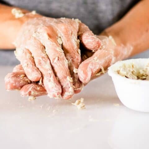 Applying a hand mask with a bowl of mask on the counter.