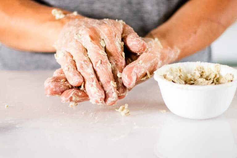 Applying a hand mask with a bowl of mask on the counter.