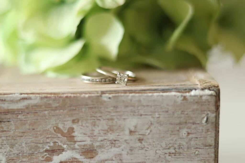 Two diamond rings after being cleaned by a diy ring cleaner and drying on a wooden box.