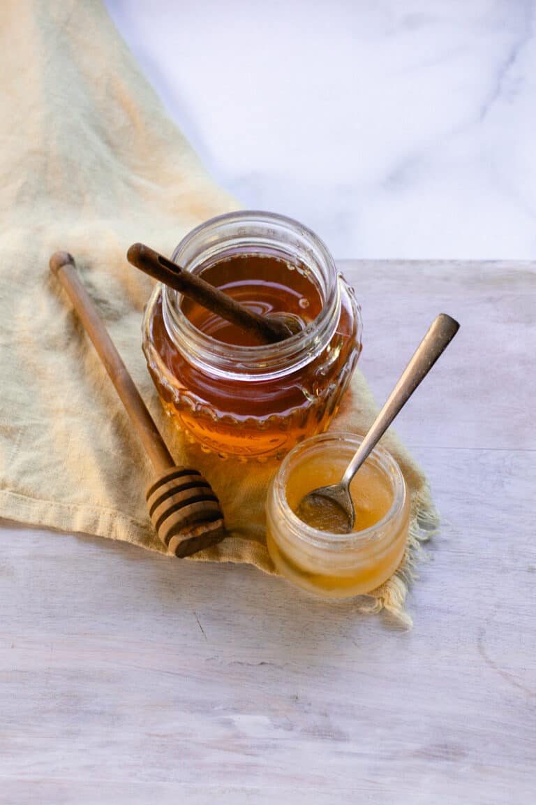 Our DIY hydrating lip mask made with honey and coconut oil on a wooden table.