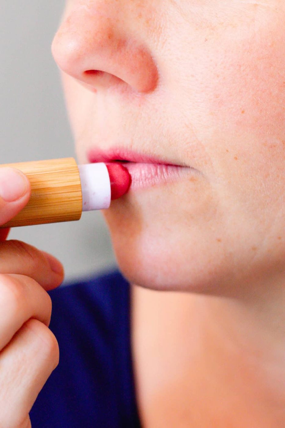 Applying homemade lipstick to the lips.