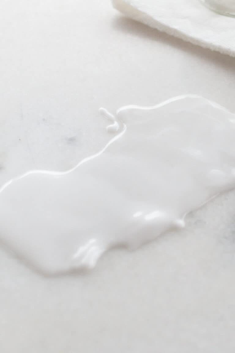 Applying a baking soda paste to a white marble surface.