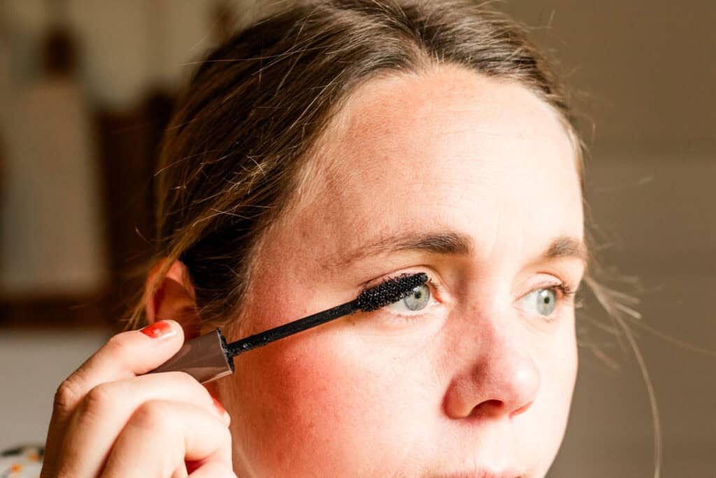 Applying homemade mascara with an applicator brush.