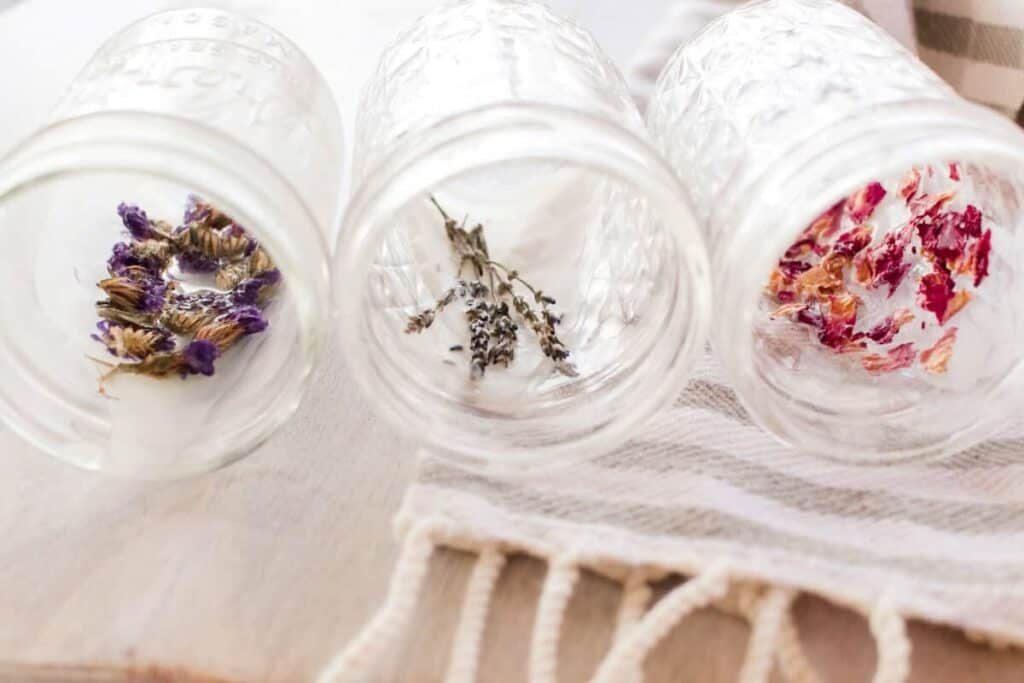 Empty jars with dried flowers laid against the wall of the jar.