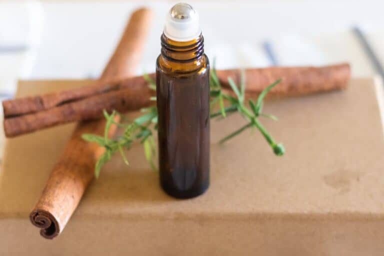 mens essential oil cologne in glass amber roller bottle with cinnamon sticks