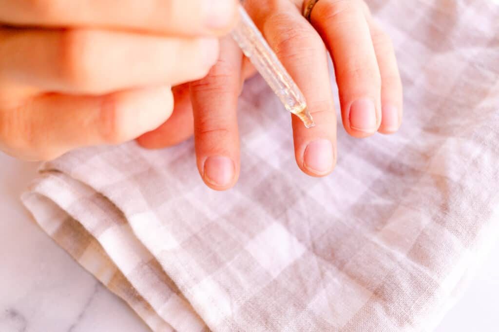 Applying the nail serum to the base of our fingernails.