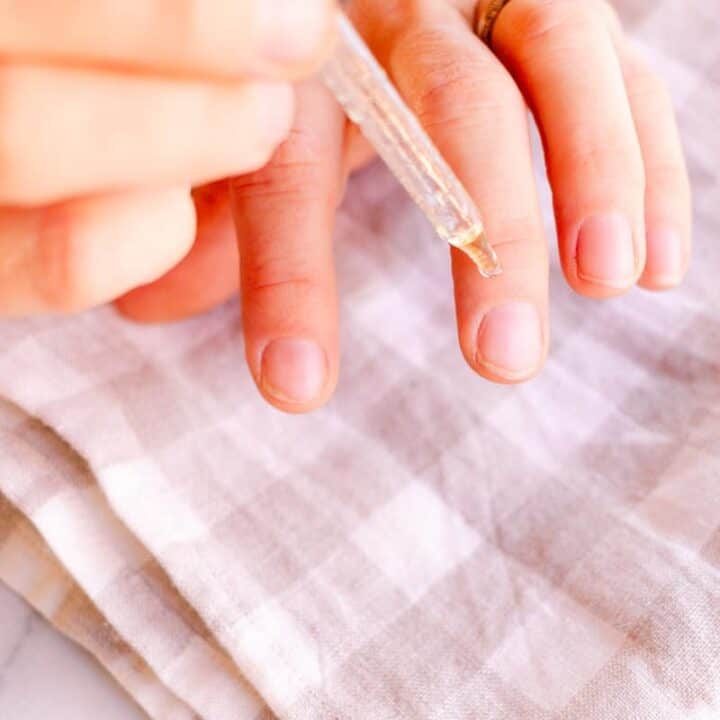 Applying a nail growth serum to the fingernails.