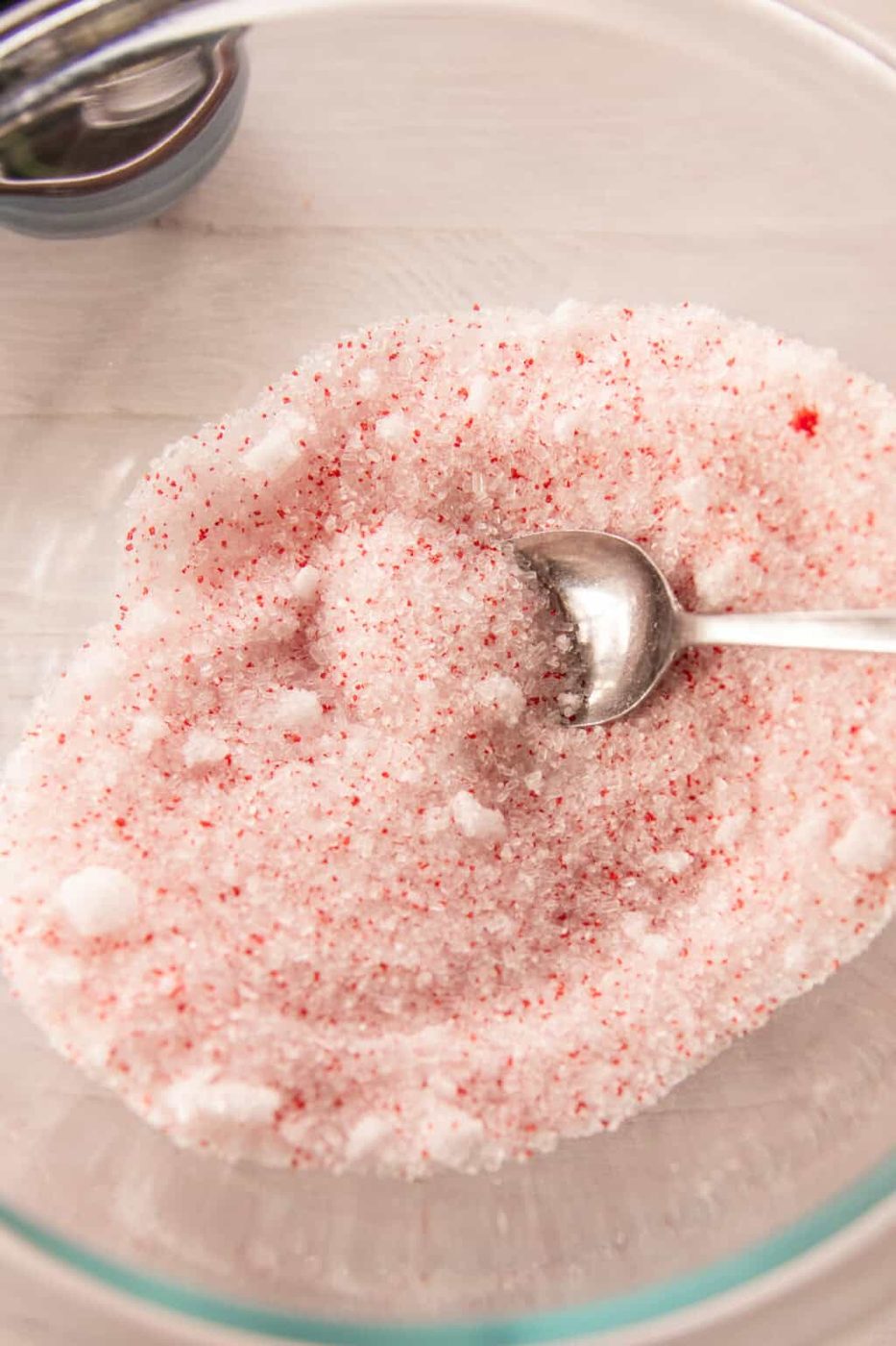 A bowl with epsom salt and red sprinkles.