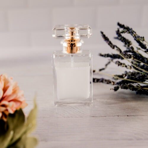 A glass bottle of homemade perfume with flowers.