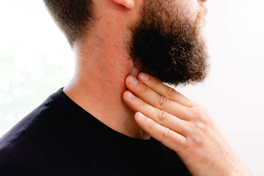 Smearing the pre shave oil onto our neck with our fingers.