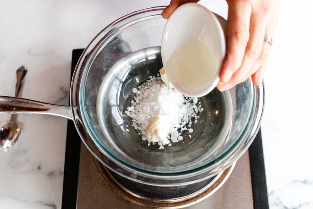 Adding oils to a double boiler.