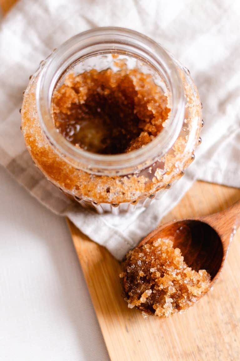 Using a wooden spoon to scoop out a portion of the DIY scalp scrub to put into our hair.