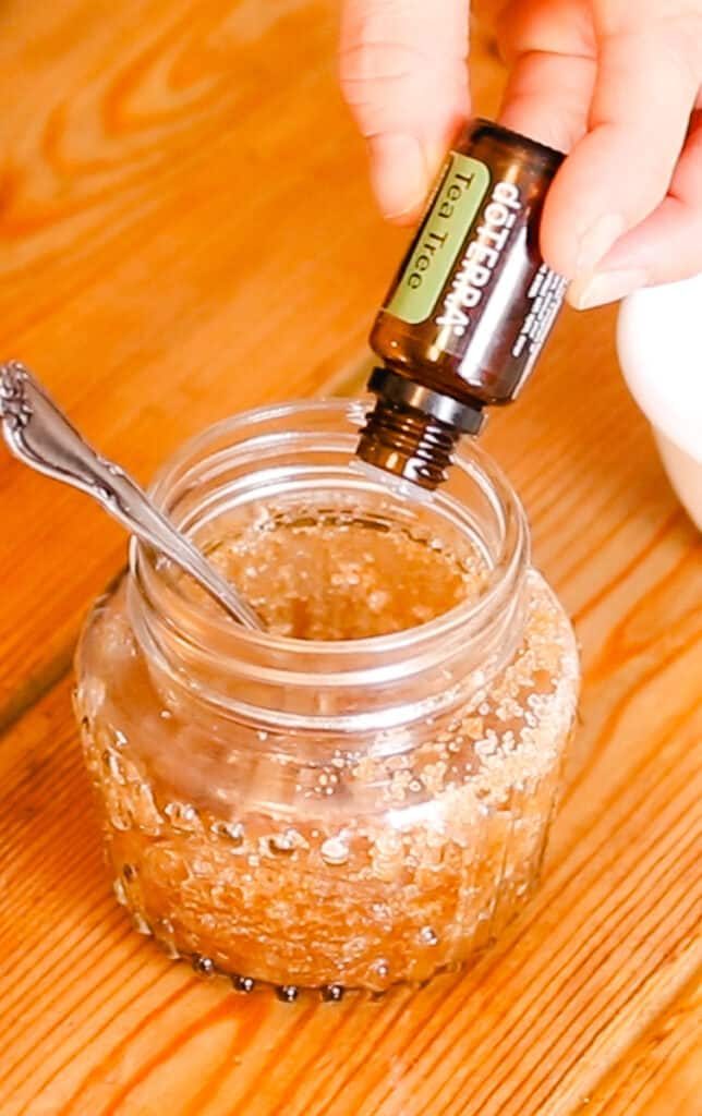 Adding tea tree essential oil to the jar.
