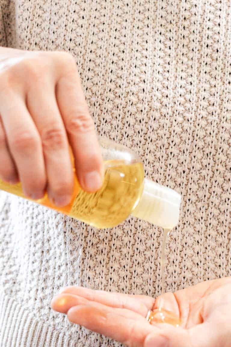 Pouring the shower oil into the palm of our hand.