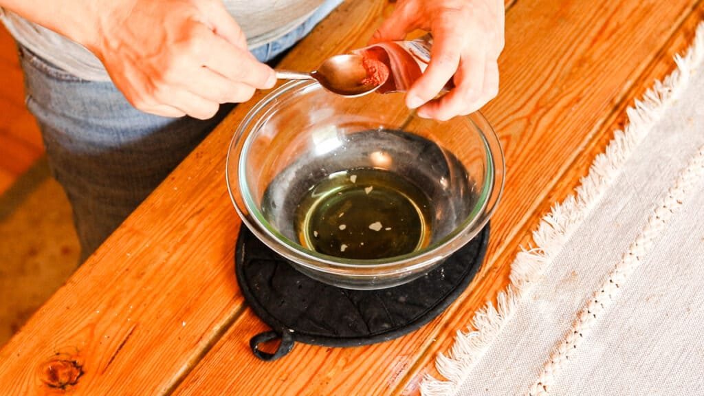 Adding the mica powder for color to the tinted lip balm.