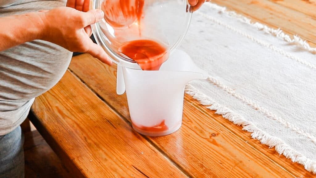 Transferring the tinted lip balm mixture to a pourable container.