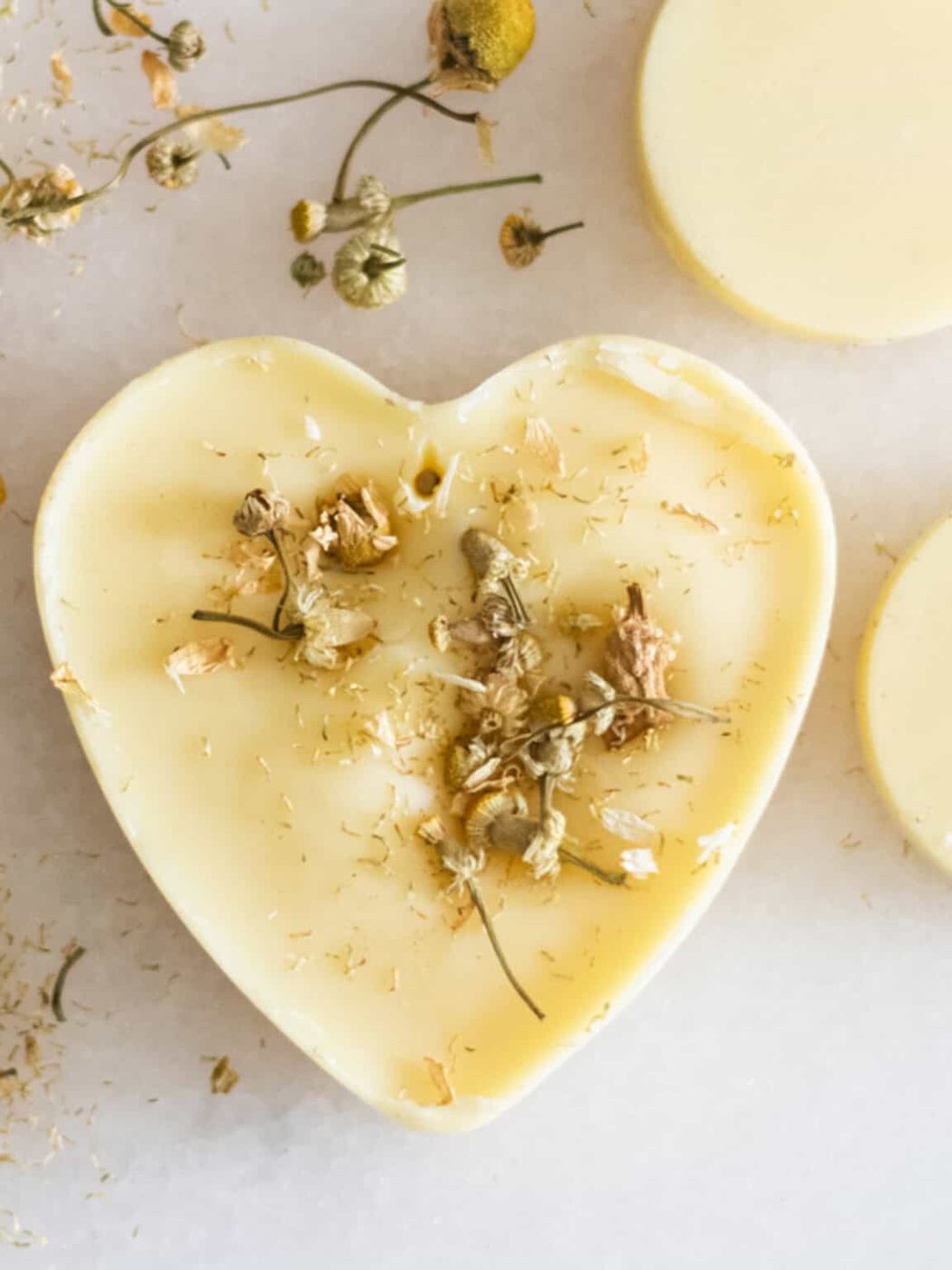 A heart-shaped wax air freshener with dried flowers in it.