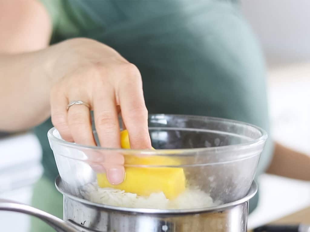 Adding beeswax to a double boiler.