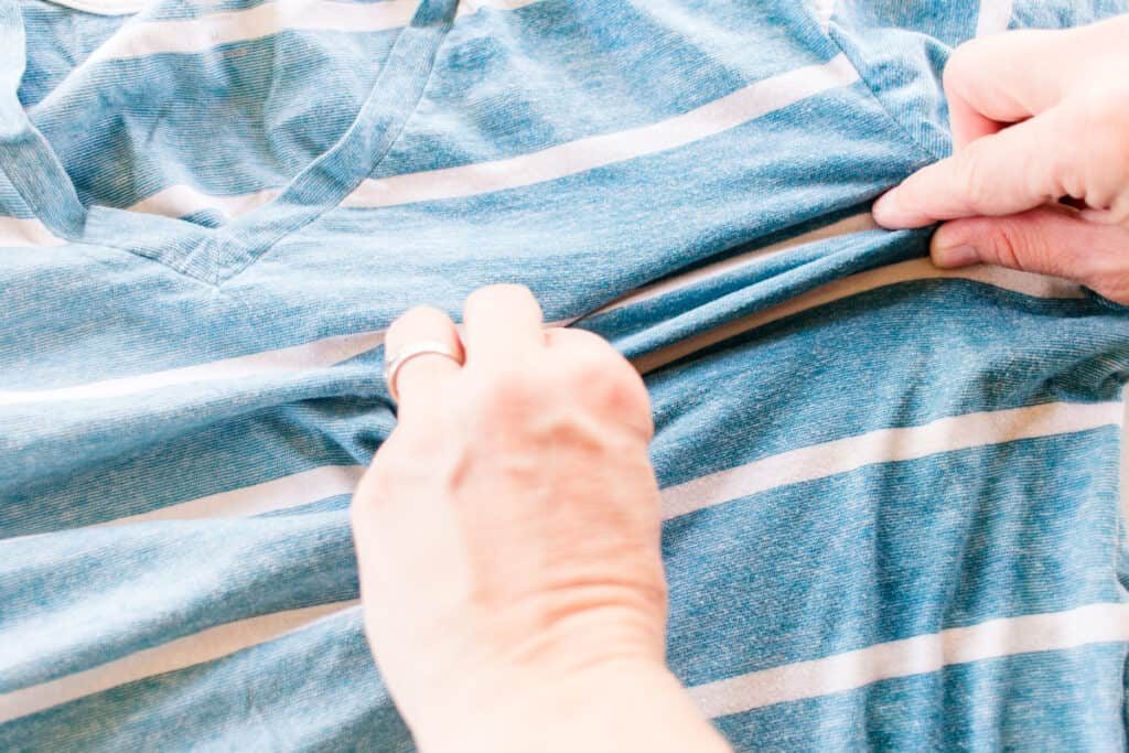 Using a wrinkle release spray on clothing.