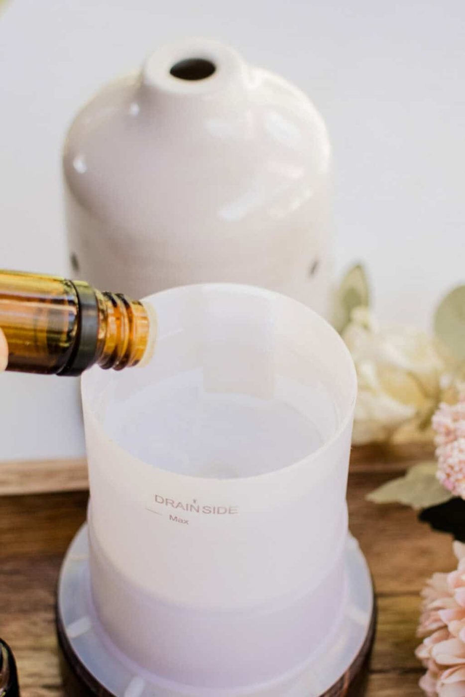 Adding essential oils to the diffuser reservoir.