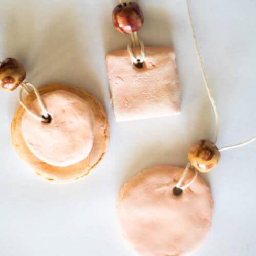 Three essential oil diffuser necklaces on a white countertop.