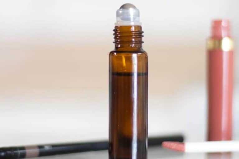 An amber colored 10mL rollerball filled with oils for brow growth.