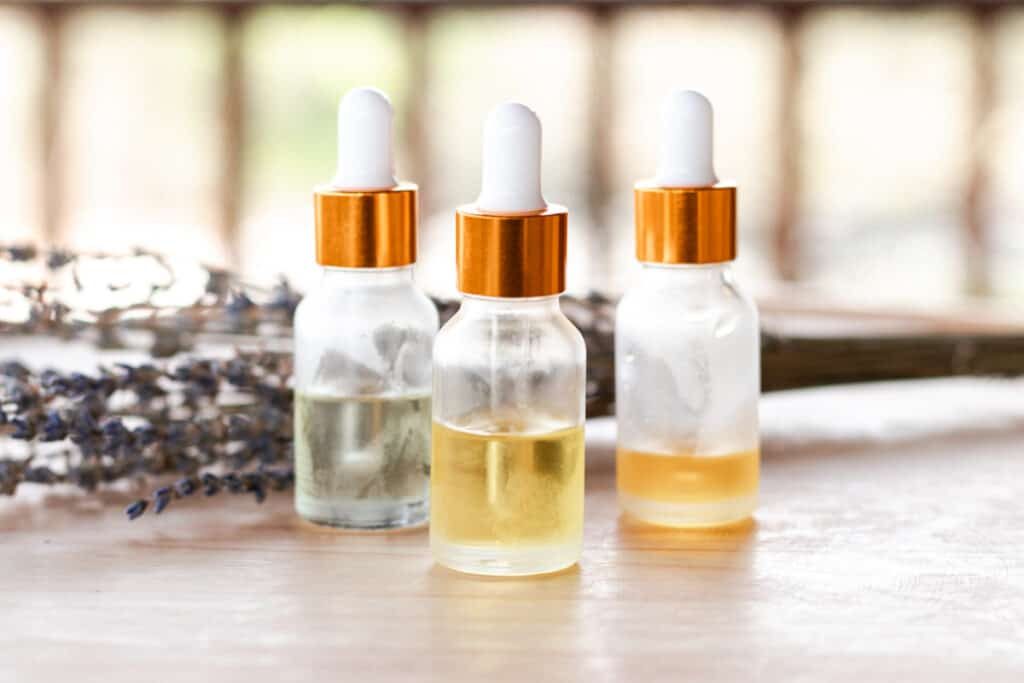 Anti wrinkle serums on a wooden table with a white dropper top and clear bottles they are stored in.