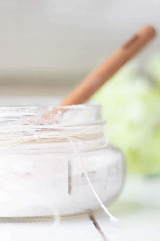 small mason jar of fizzing bath salts with wooden spoon.