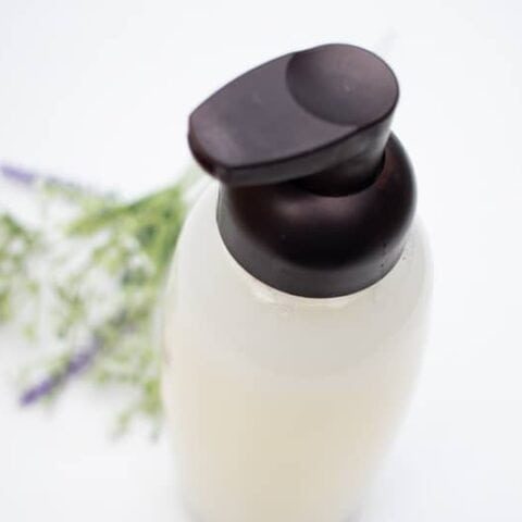 Clear foaming hand soap dispenser on white vanity.