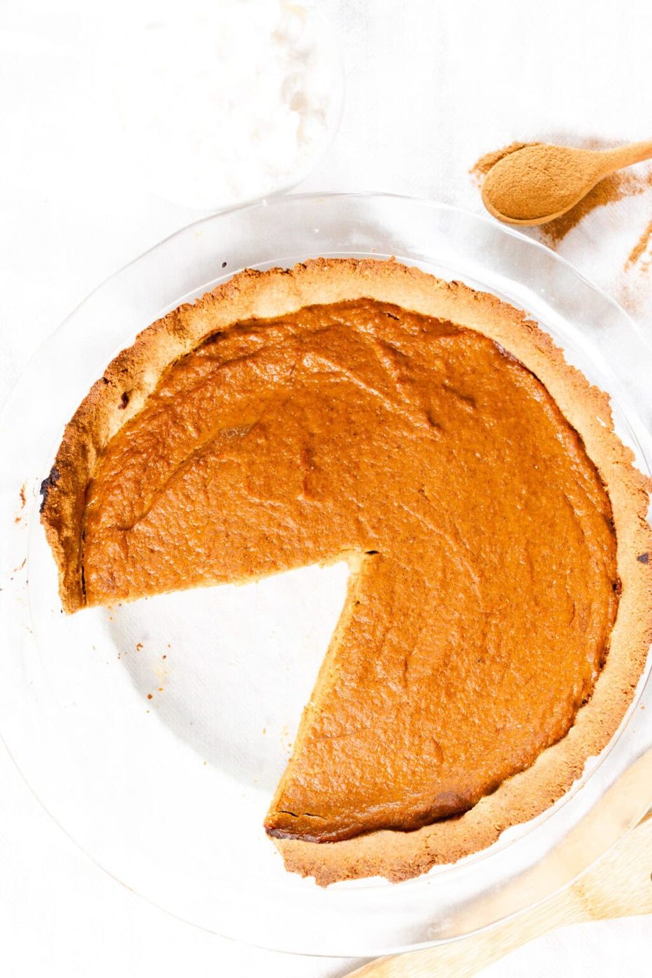A healthy pumpkin pie with a slice taken out.