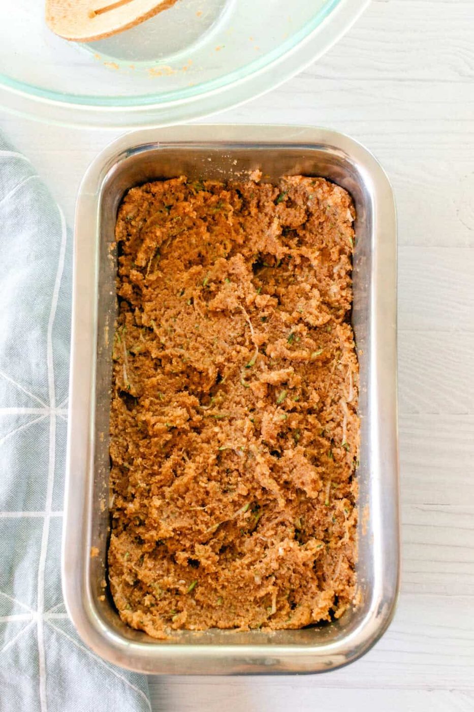 Bread batter spread into a loaf pan.