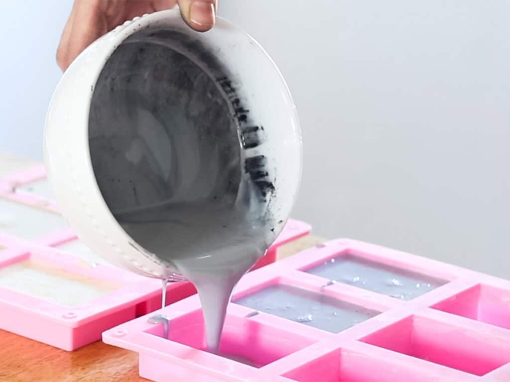 Pouring melted soap base into silicone soap molds.