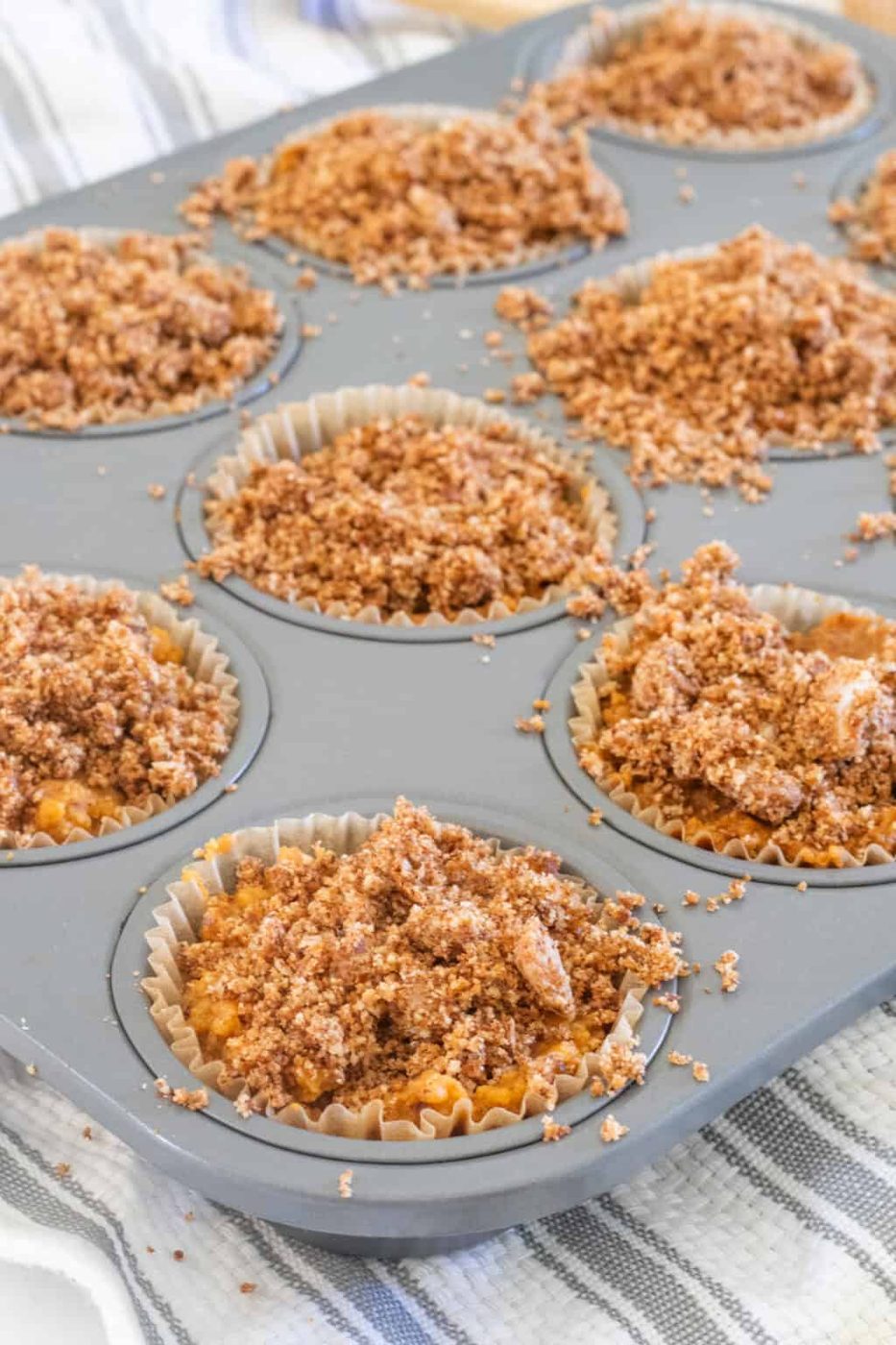 Pumpkin Crumble is spread on top of the muffins while they are still in the cookie tray.