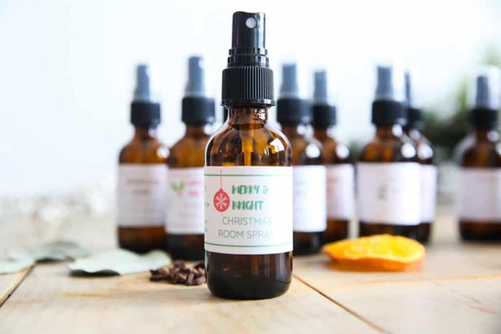 Amber bottles of holiday room spray on a wooden countertop.