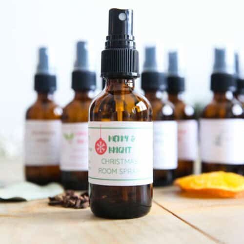 Amber bottles of holiday room spray on a wooden countertop.