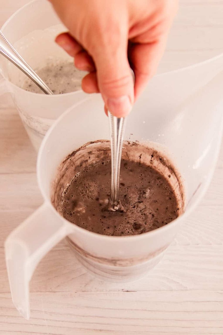 Stirring a bowl of melted soap base with mica powder.