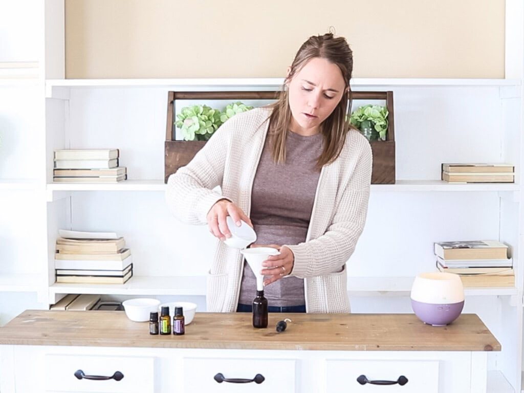 Pouring ingredients into an amber bottle with a funnel.