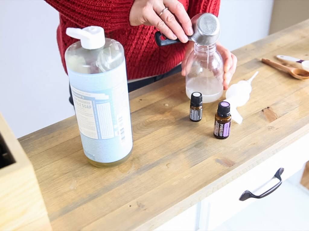 Pouring castile soap into a foaming soap dispenser.