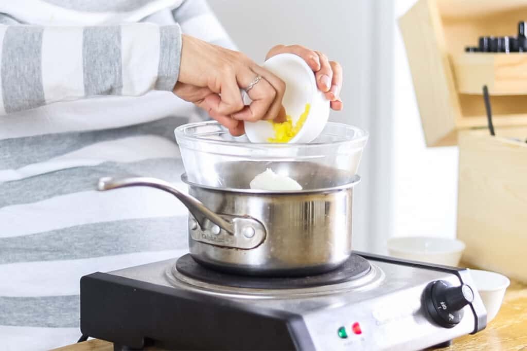 Pouring ingredients into a double boiler.