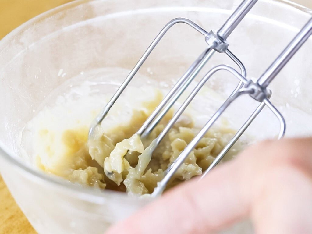 Whipping homemade body butter with a hand mixer.
