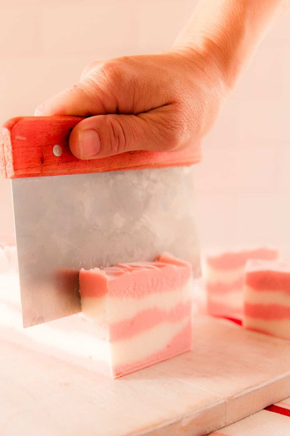 Cutting candy cand soap with a soap cutter.
