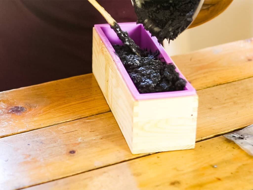 Pouring the soap mixture into a loaf soap mold.
