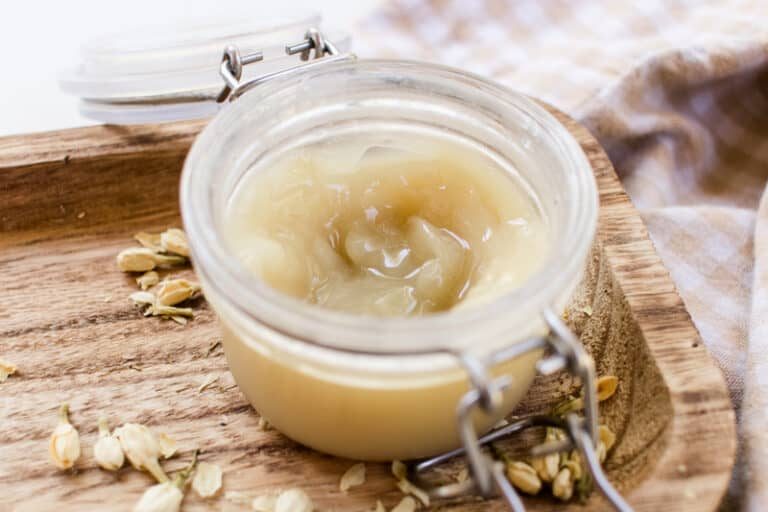 A jar of curl enhancing cream on a wooden tray.