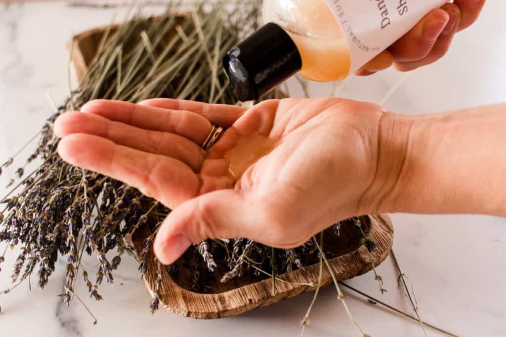 Pouring homemade dandruff shampoo onto the hands.