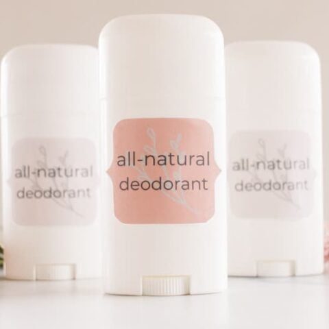 3 DIY natural deodorants with white containers and fragrant flowers.