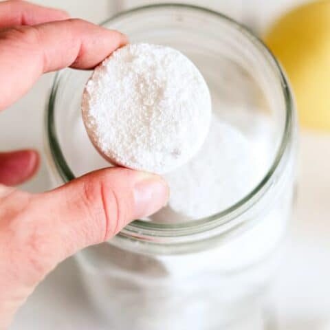 DIY dishwasher tabs being added to an airtight storage jar.