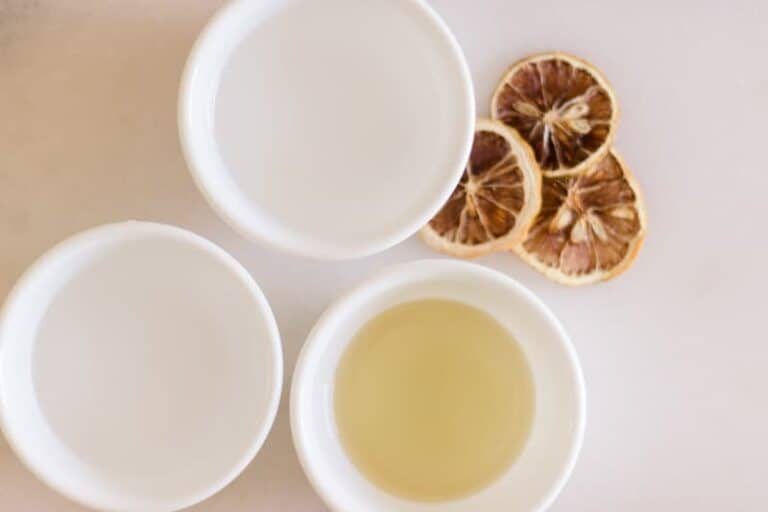 Three white bowls with water, vinegar, and olive oil in it.
