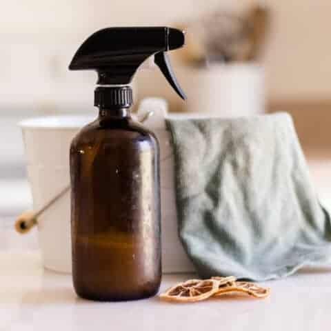A bottle of dusting spray with a microfiber cleaning cloth.
